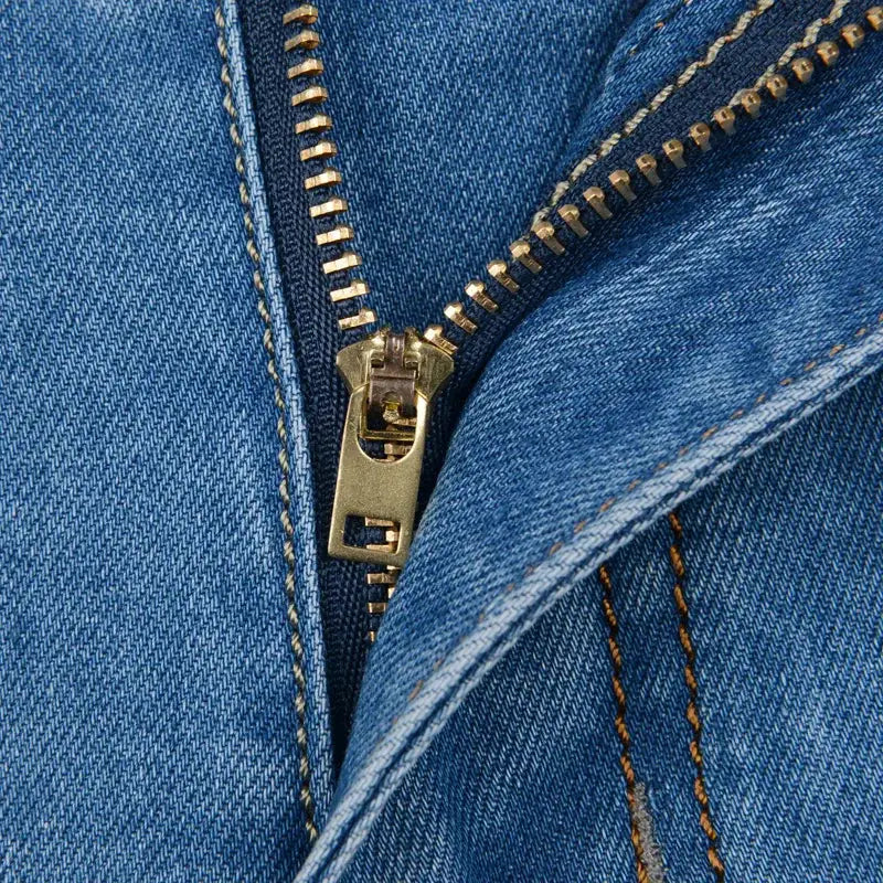 Men's denim shorts zipper close-up in light blue denim fabric