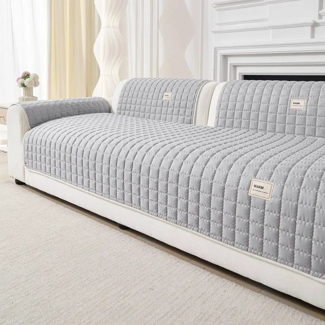Quilted gray sofa slipcover with anti-slip backing for a 3-seat sofa and matching armrest cushions.