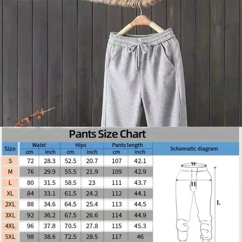 Heavy duty men's gray sweatpants with drawstring, loose straight fit, hanging on a wooden backdrop