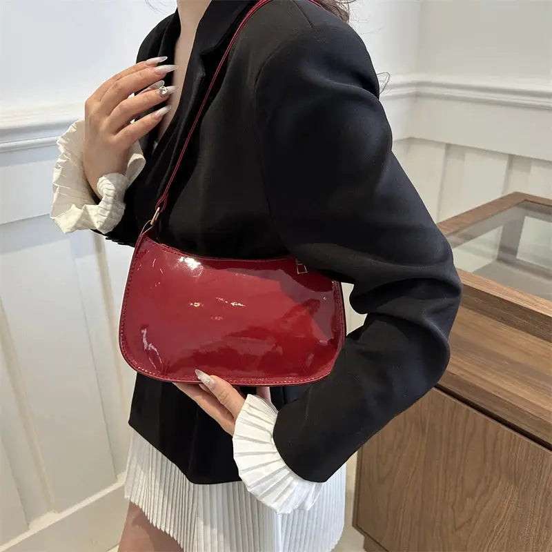 Red patent PU leather shoulder bag for women with glossy finish.