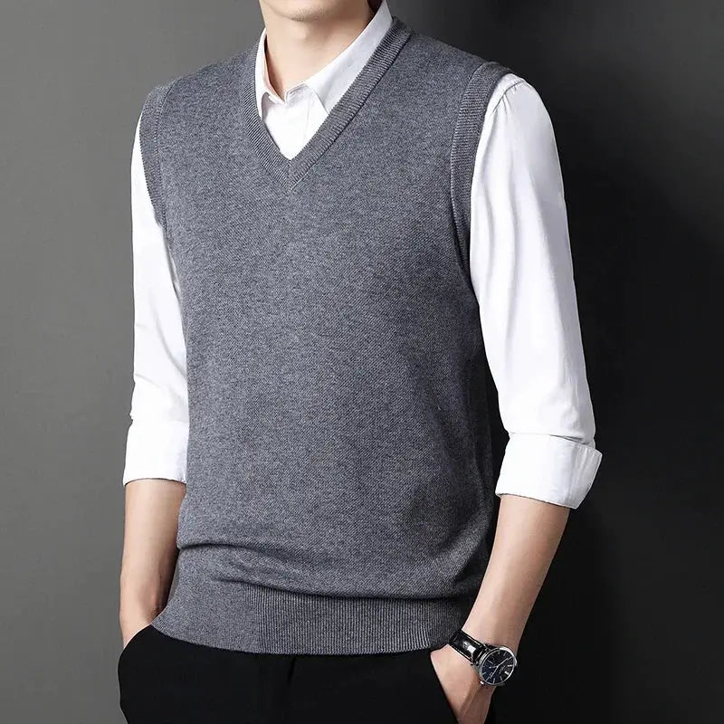 Men's gray V-neck knitted vest layered over white shirt, versatile autumn-winter top
