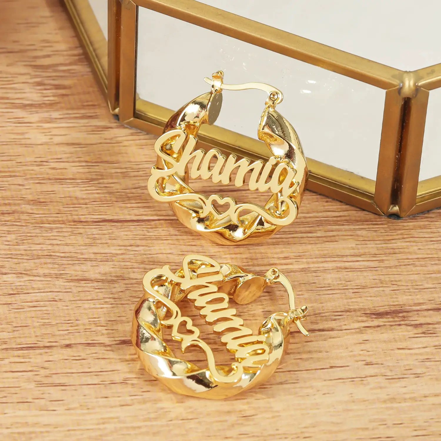 Pair of gold-tone custom name hoop earrings with scripted lettering and heart accents