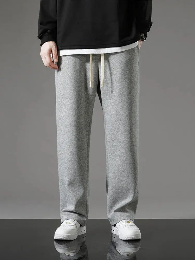 Men's grey cotton sweatpants with drawstring, loose wide-leg track pants.