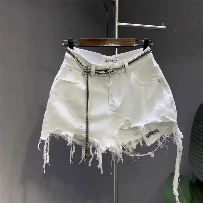 White irregular denim mini skirt with distressed hem and silver chain belt
