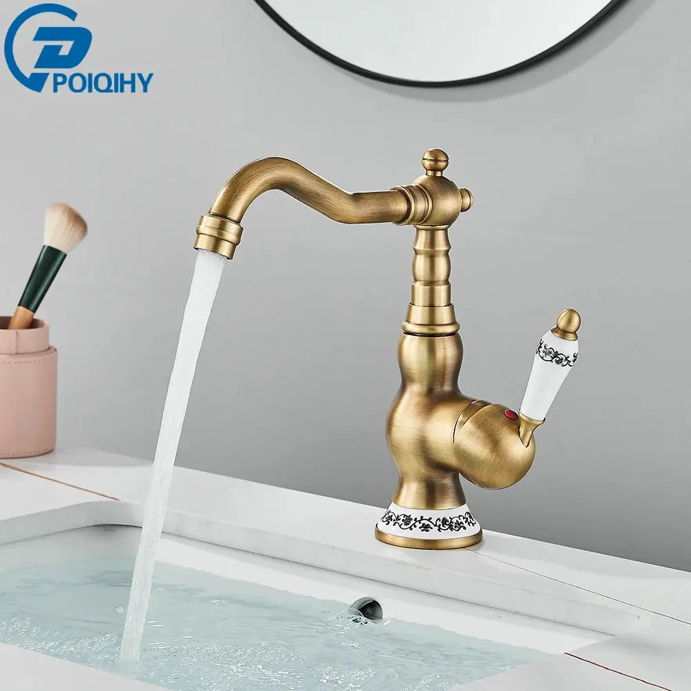 Antique brass bathroom faucet by Simples Market with rotating spout and white ceramic handles with black detailing.