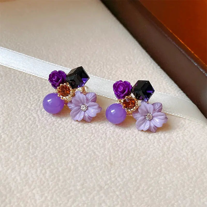 Colorful flower earrings with lilac petal charms, purple beads, and black-purple geometric studs
