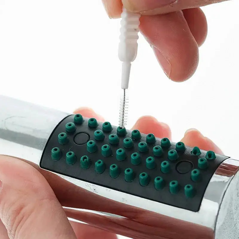 Shower cleaning brush head with green micro nylon nozzles on a black grip, white wand in use.