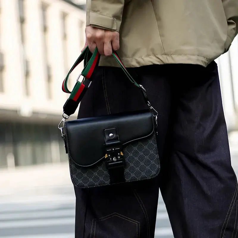 Men's crossbody bag from Simples Market with jacquard-pattern body, black leather flap and green-red striped strap