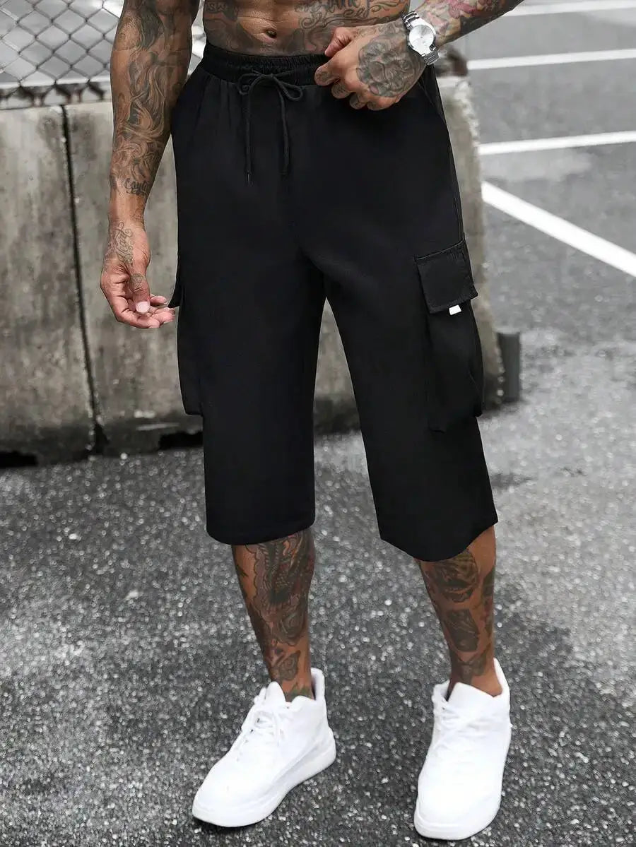 Manfinity Homme men's black cargo shorts with drawstring and side cargo pockets, baggy capri length.
