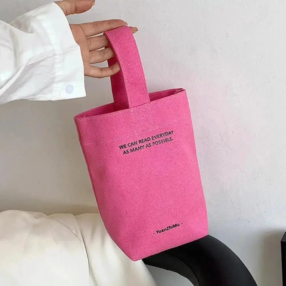 Pink canvas tote bag with short handles, casual shopper style.