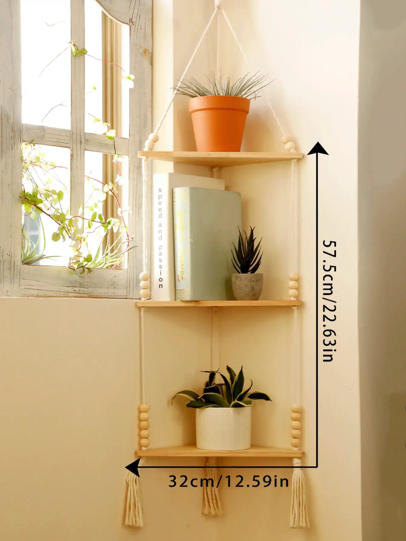 Three-tier wooden triangle corner floating shelf with rope hangers and tassels in natural wood finish.