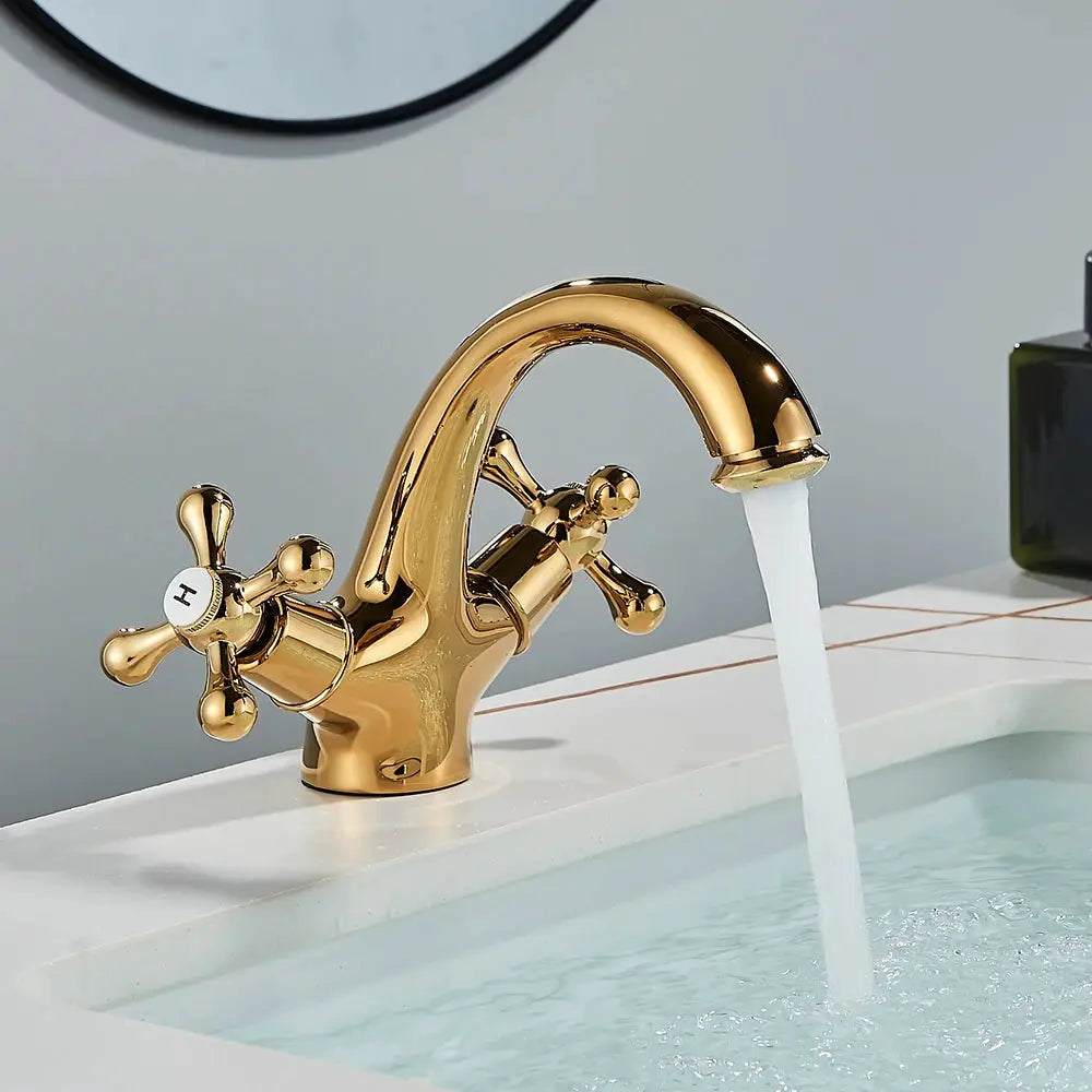 Antique brass bathroom faucet with two cross handles, deck-mounted hot and cold water.