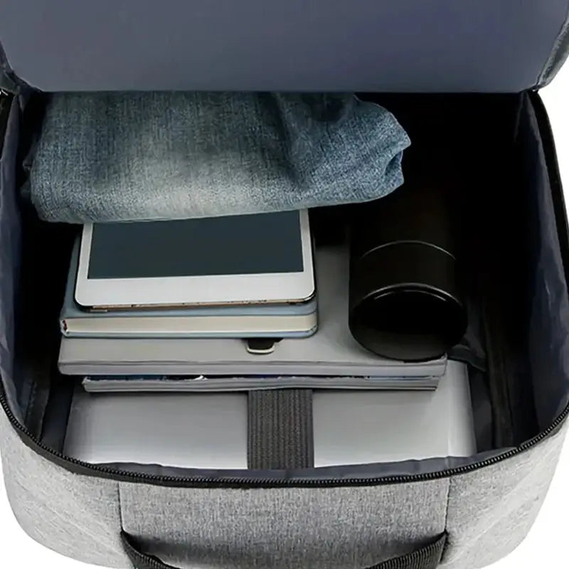 Backpack by Simples Market in neutral gray with tablet, books, clothes and camera lens inside