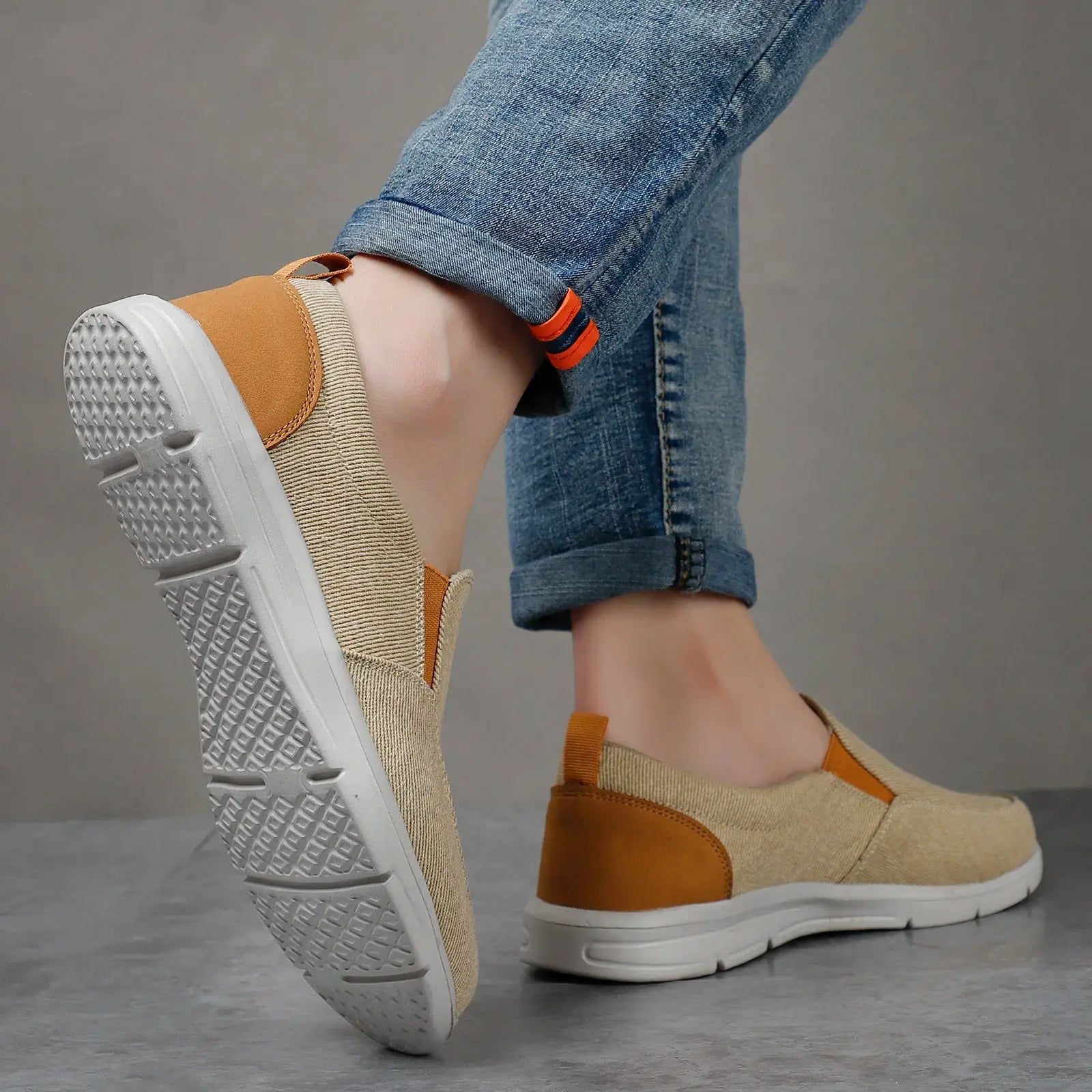 Men's tan canvas slip-on sneakers with brown leather heel patch and white sole