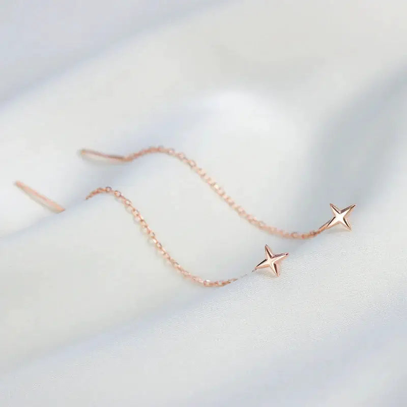 Simples Market rose gold tone star drop earrings with long curved wire chain and star bead ends