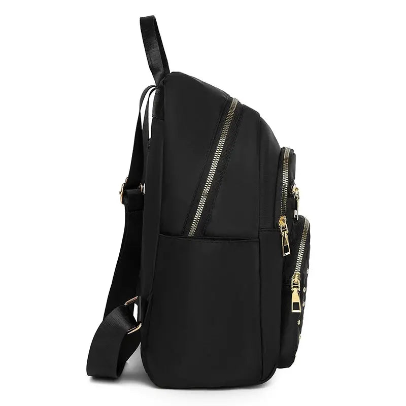 Travel backpack in black with gold-tone zippers, multiple compartments and adjustable straps for travel and everyday use