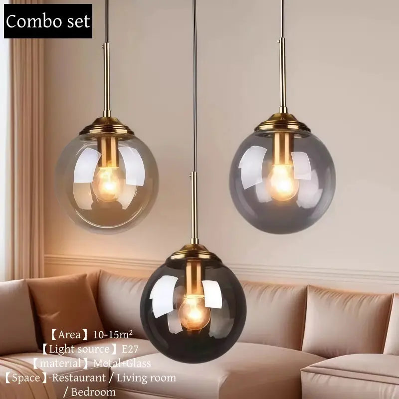 Three-globe glass pendant light set with smoky gray glass globes and brass hardware.