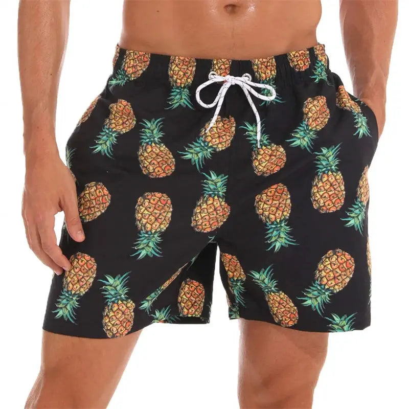 Men's black pineapple-print swim trunks with white drawstring.