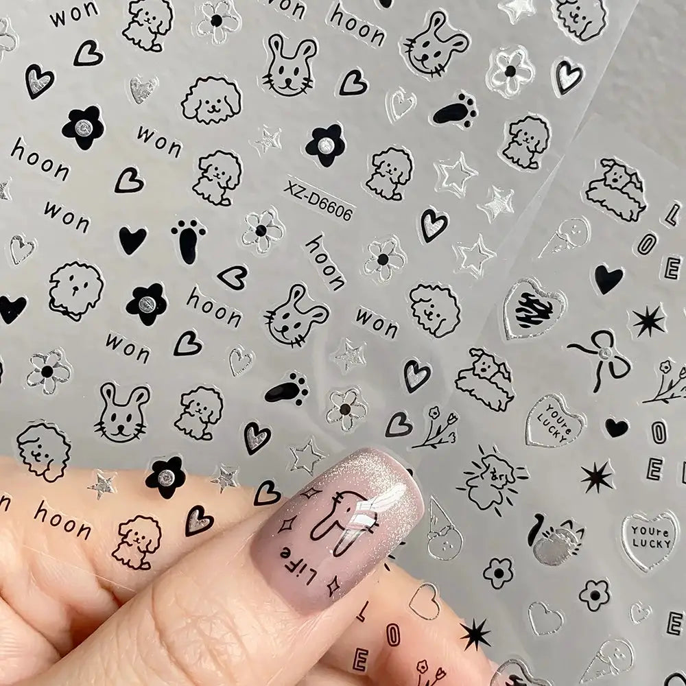 12-sheet cartoon nail stickers with black line-art animals, hearts, stars and flowers for manicure.
