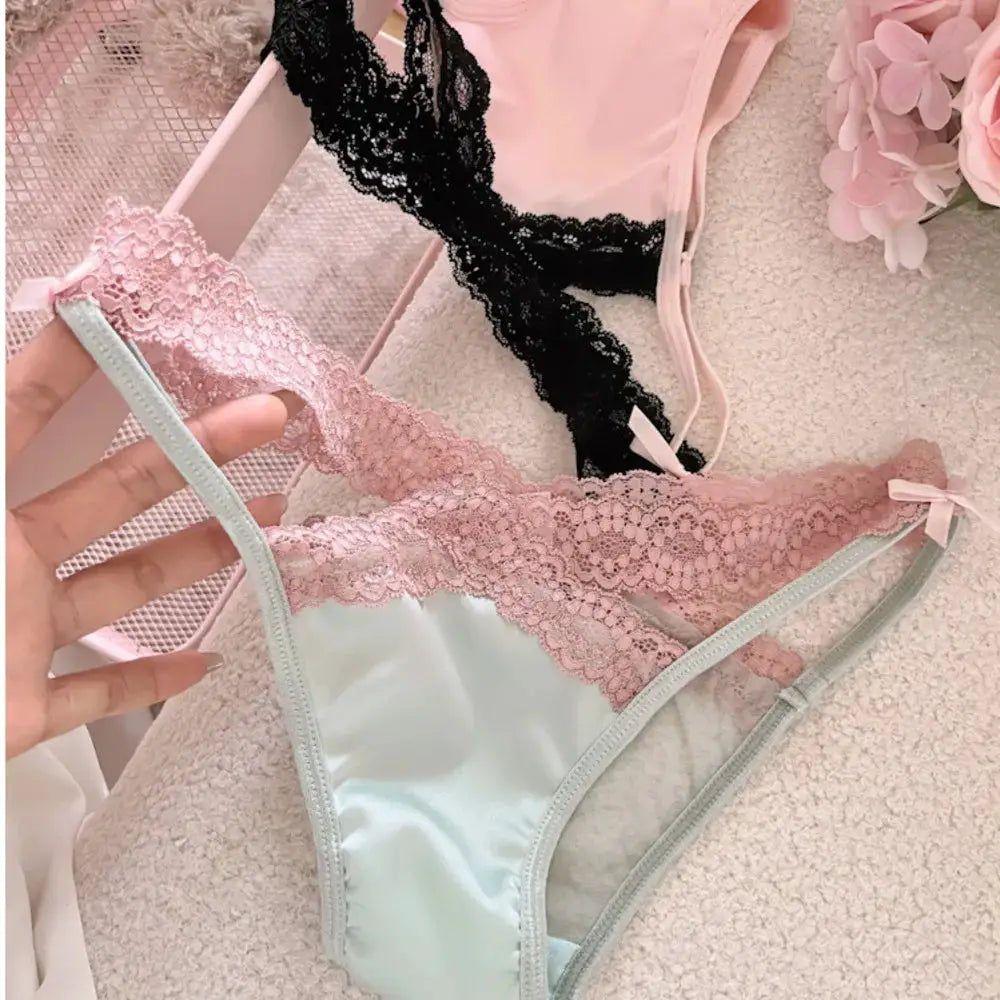 Lace panty in mint green with pink lace trim and bow; pink and black lace lingerie pieces visible in background
