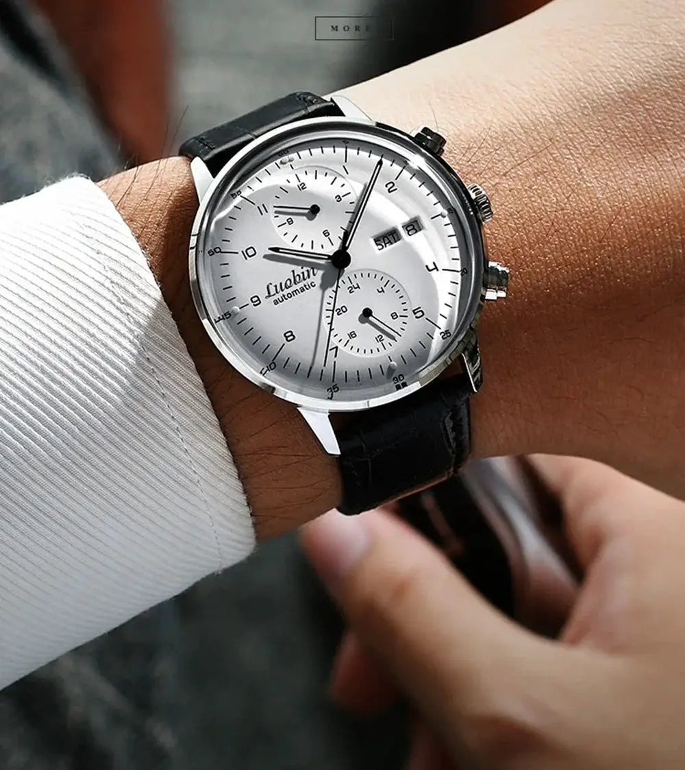 Men's automatic mechanical wristwatch with silver dial, chronograph subdials, and black leather strap