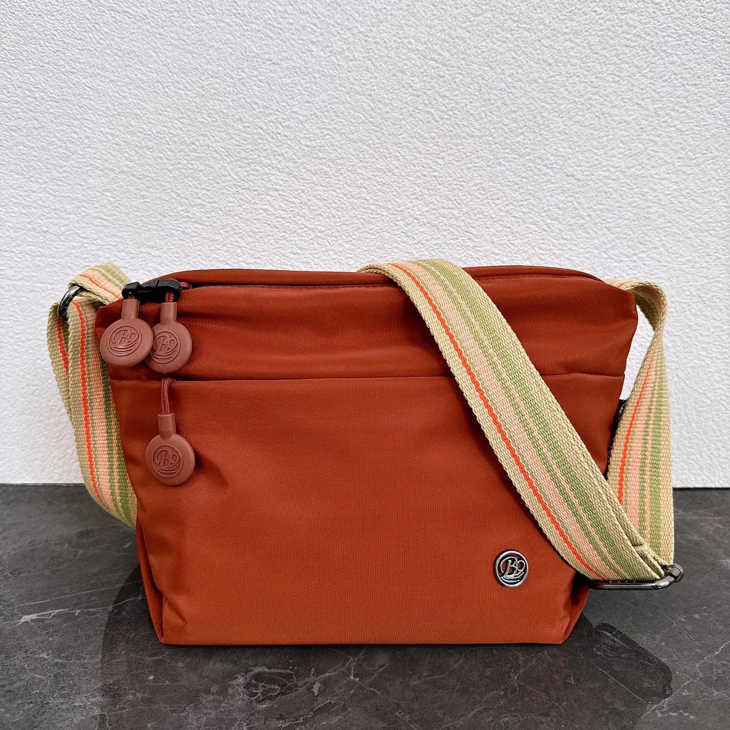 Simples Market ultra-light nylon crossbody bag, burnt orange with beige-striped adjustable strap and zipper closure