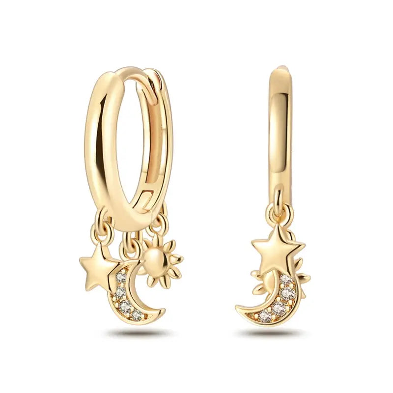 Gold-tone hoop earrings pair with celestial charms (moon, star, sun) and crystal accents.