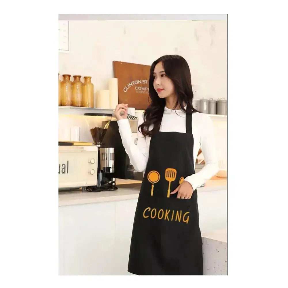 Black kitchen apron with orange utensil icons and COOKING lettering