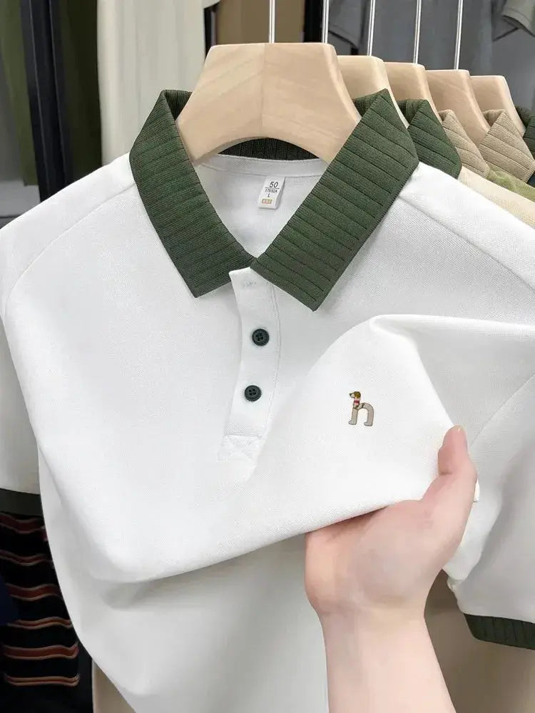 Six polo shirts on hangers; white polo with green ribbed collar and small dog embroidery