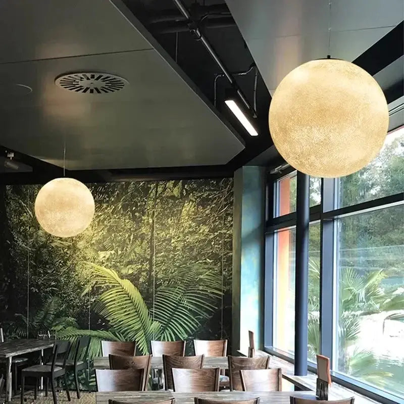 Nordic Moon LED pendant lights (2) by Simples Market; round frosted glass globes with warm glow in a cafe setting.