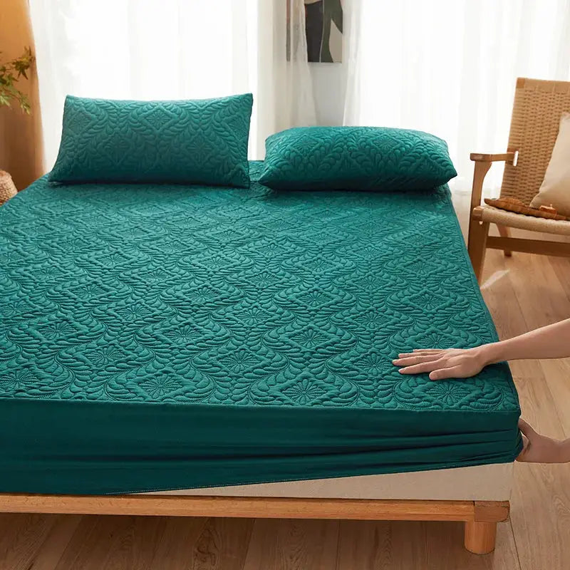 Teal quilted waterproof mattress protector fitted sheet with two pillows