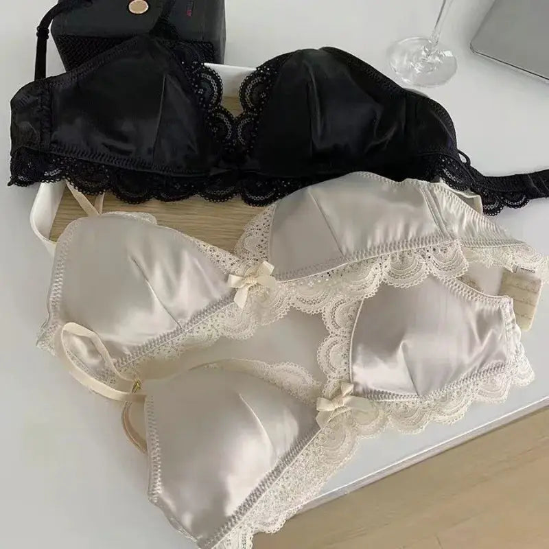 Two satin lace bras in black and ivory with bow accents