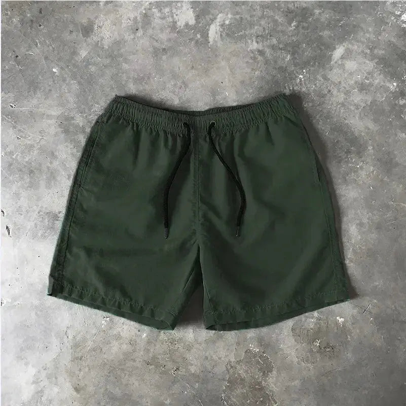 Men's green swim shorts with black drawstring; Simples Market board shorts