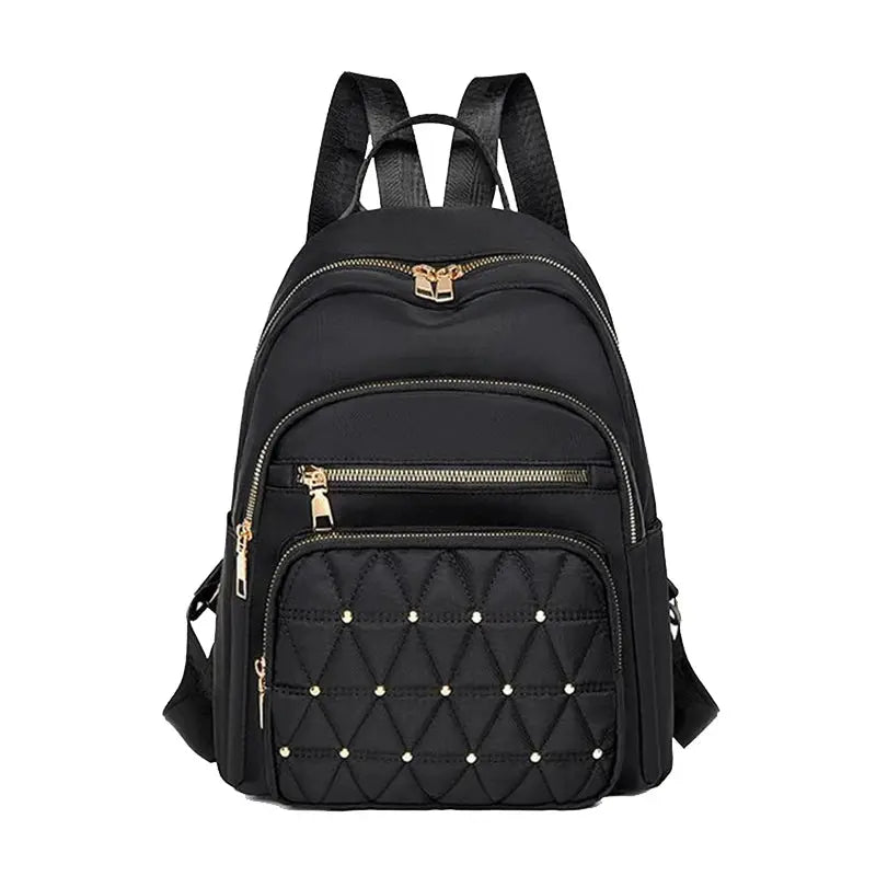 Travel backpack by Simples Market in black with gold-tone zippers and diamond-quilted front pocket.