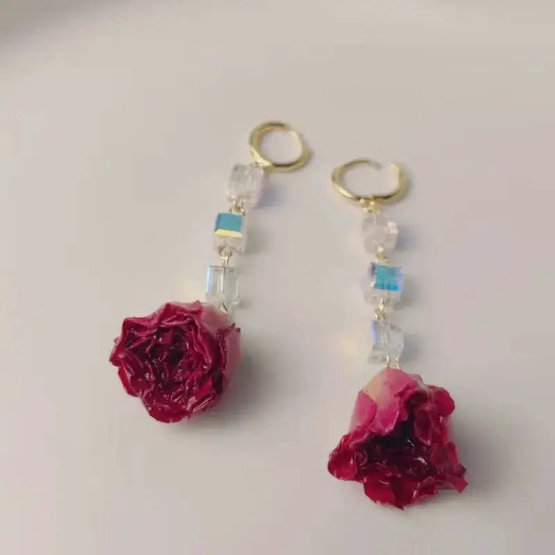 Pair of red rose epoxy resin drop earrings with crystal beads and gold-tone hoops by Simples Market