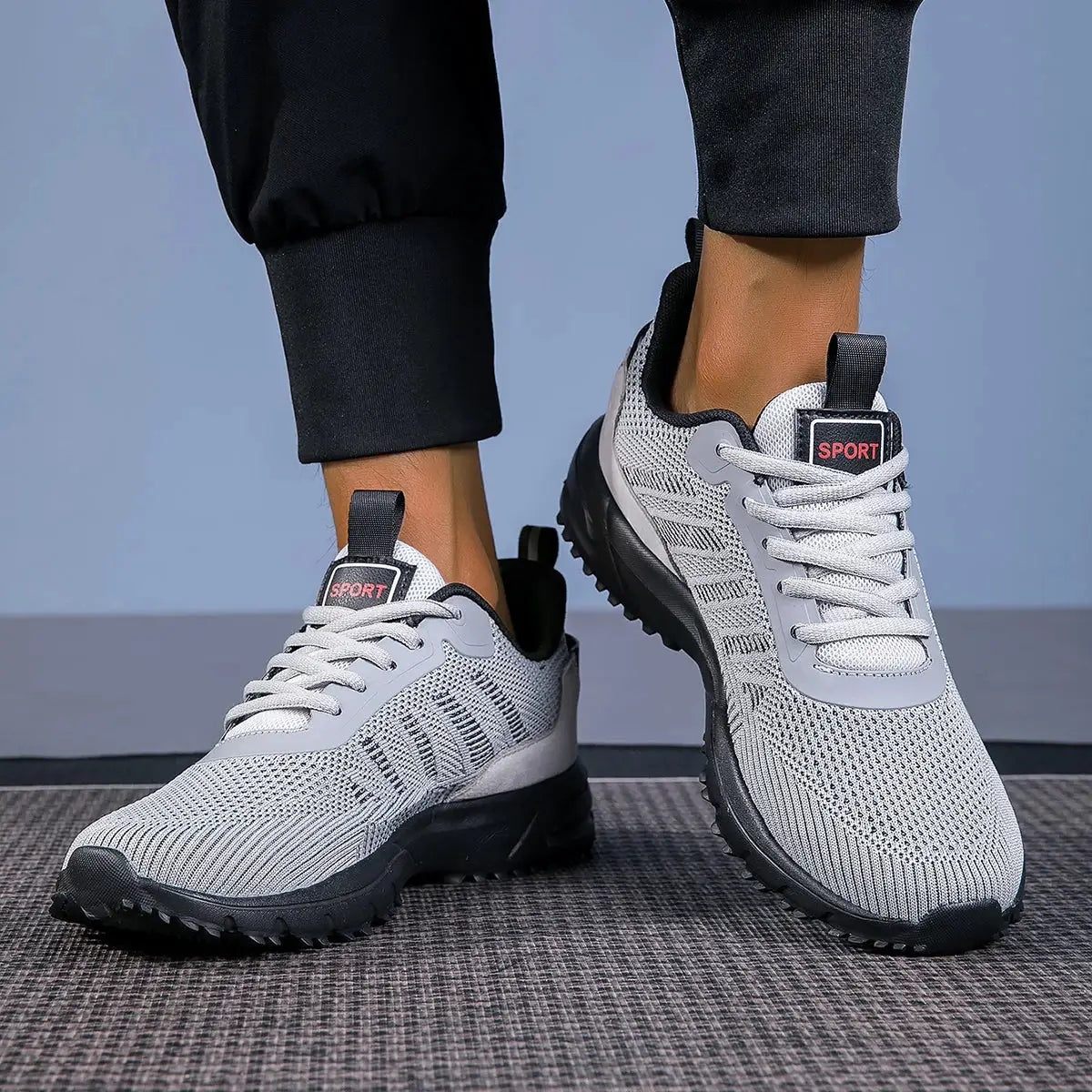 Pair of men's running shoes, lightweight gray knit upper with white laces and black outsole
