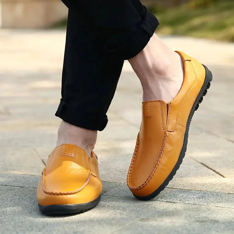 Genuine tan leather men's loafers with slip-on moccasin style and black sole.