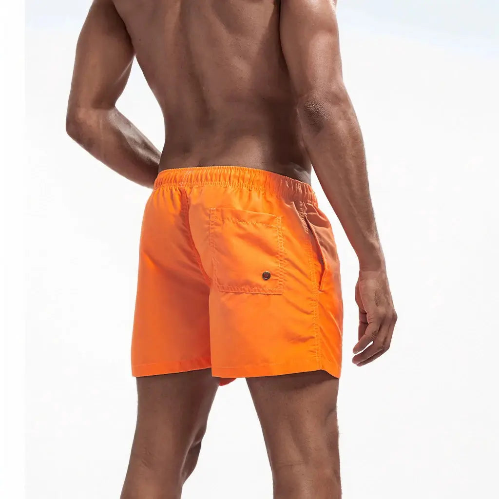 Men's orange swim shorts with back pocket and elastic waistband