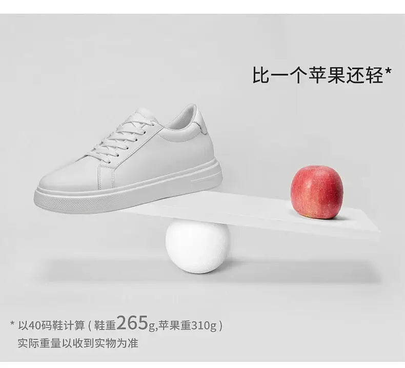 Men's white leather elevator sneakers with 6-10 cm height-increasing insoles, shown on a seesaw with a red apple
