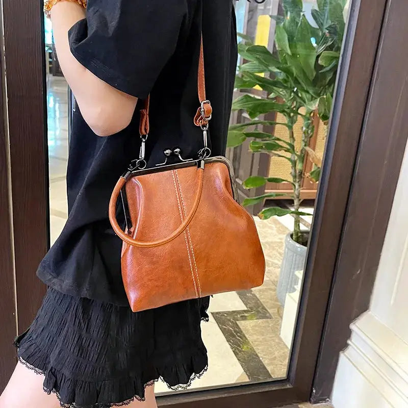 Brown PU leather vintage-style women's handbag with top metal frame closure and crossbody strap