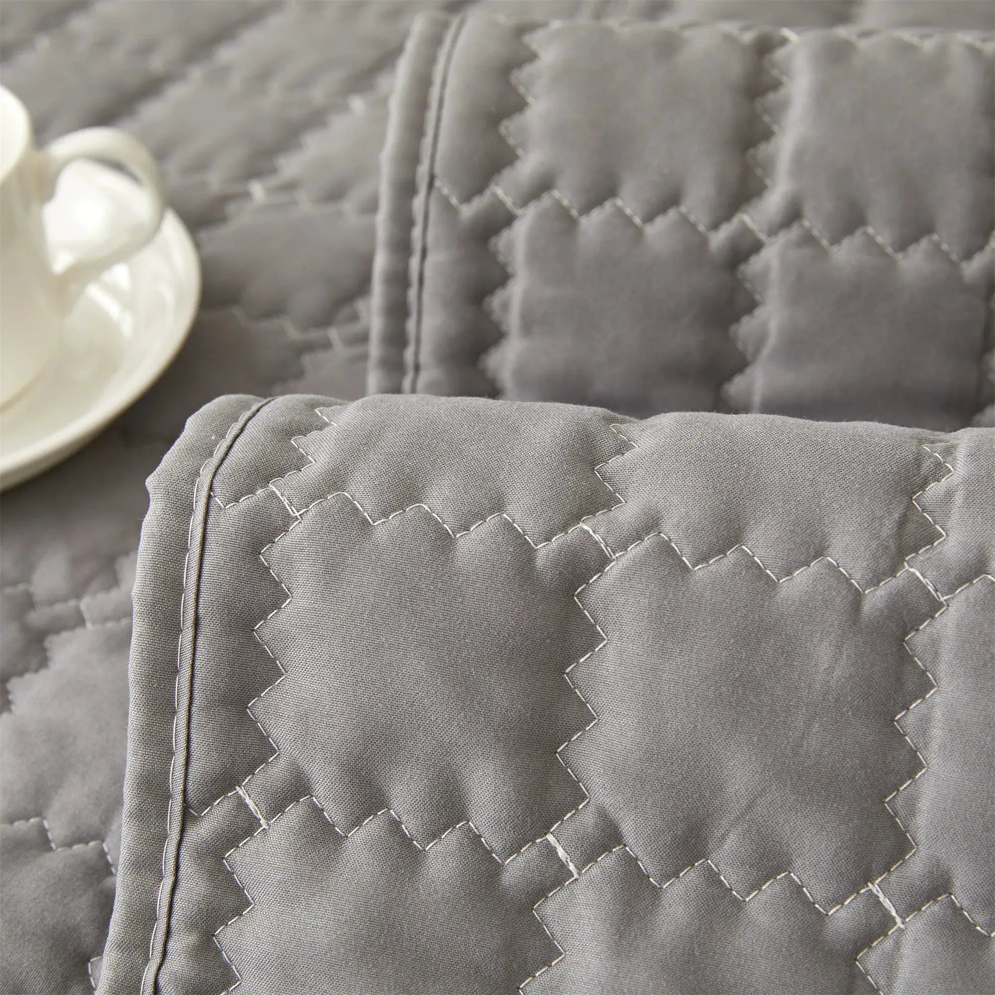 Quilted sofa cover by Simples Market in grey; anti-slip, solid slipcover for living room decor