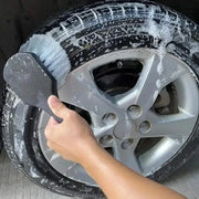 Car wheel cleaning brush with short black handle and rectangular bristle head for tire and rim washing
