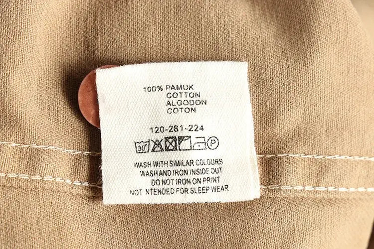 Simples Market shirt tag on tan fabric; care label shows washing icons and 100% cotton