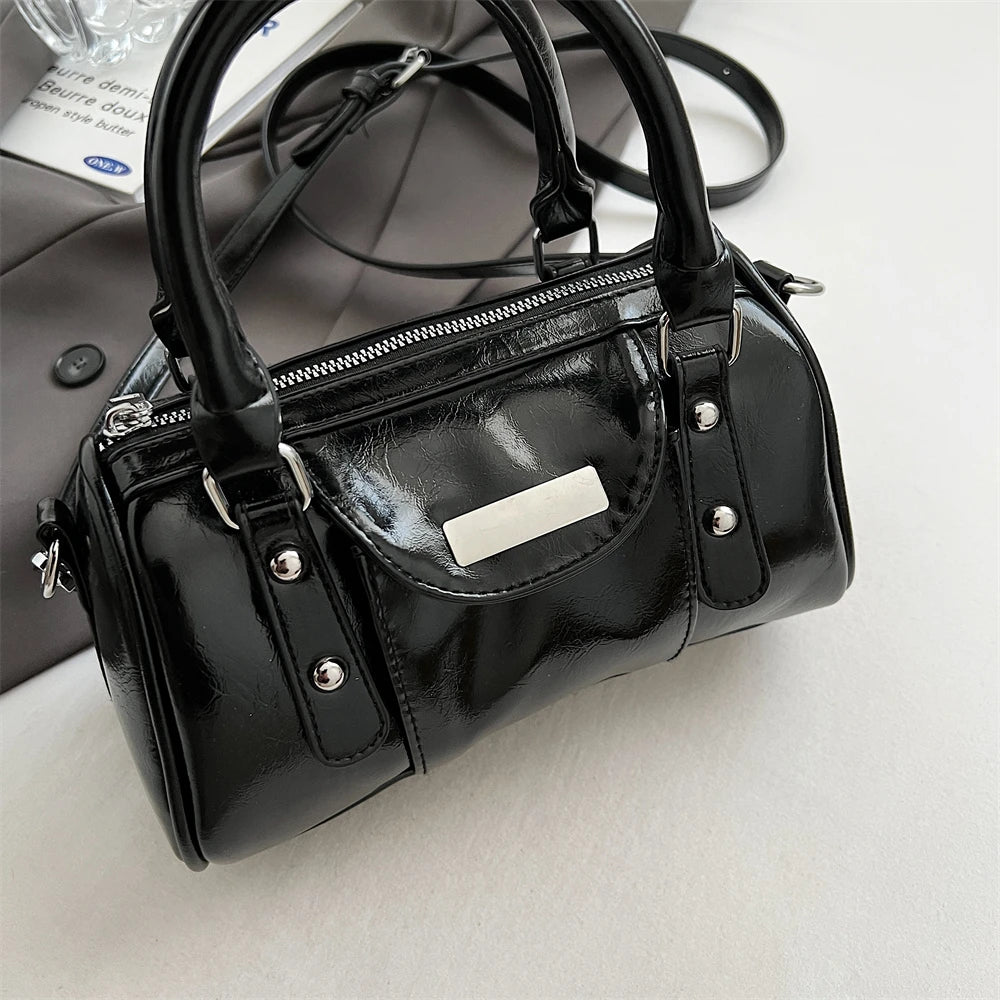 Mini top-handle bag for women in black patent PU leather with silver hardware and zip closure.