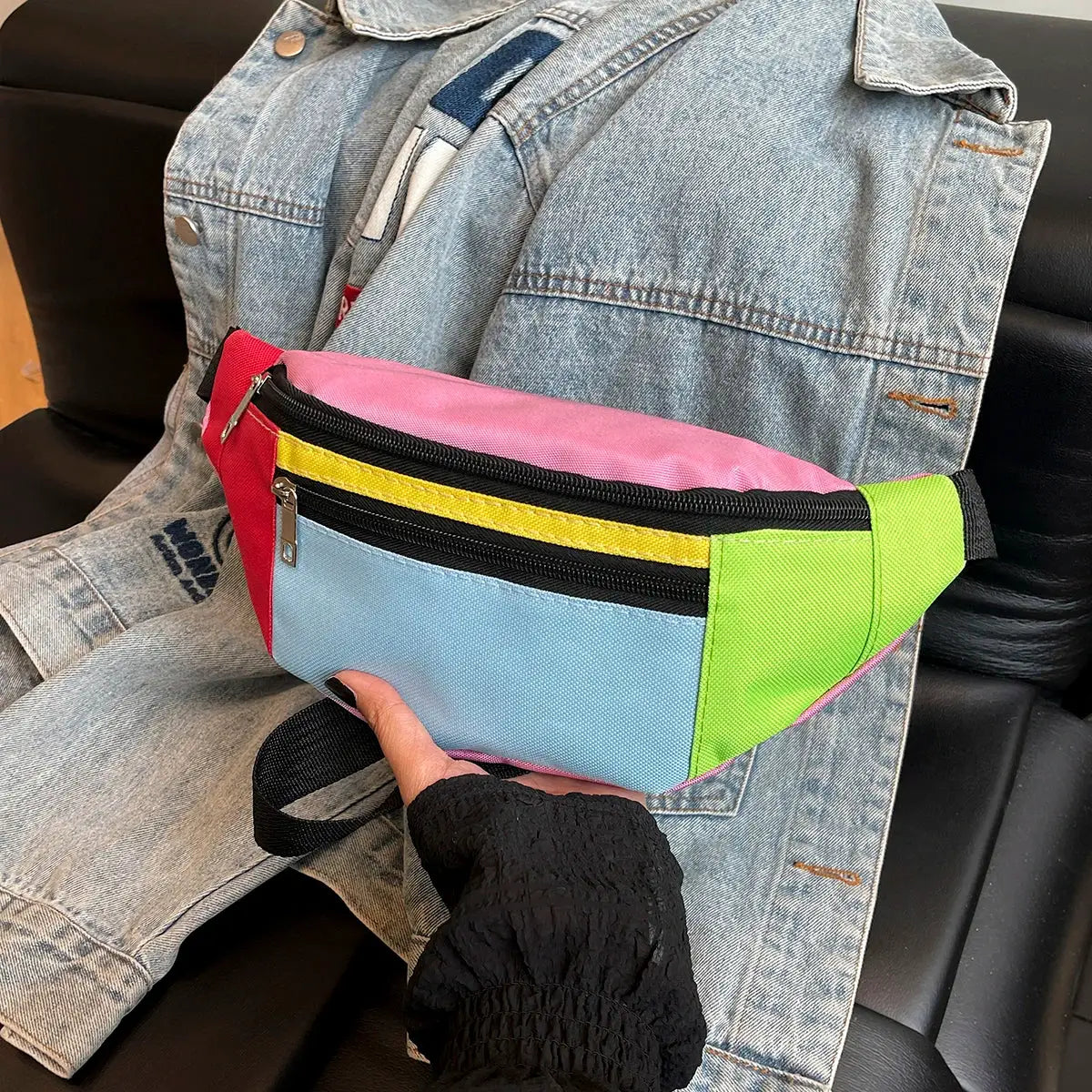 Fanny pack waist bag with neon color-block panels in pink, red, blue, yellow and green, featuring black zippers.