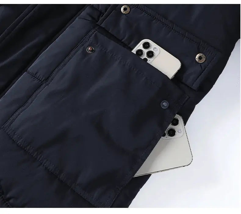 Men's navy windproof parka with multiple pockets; two smartphones tucked into pockets.