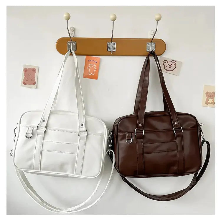 Two JK-style PU leather bags in white and brown with dual handles and crossbody straps