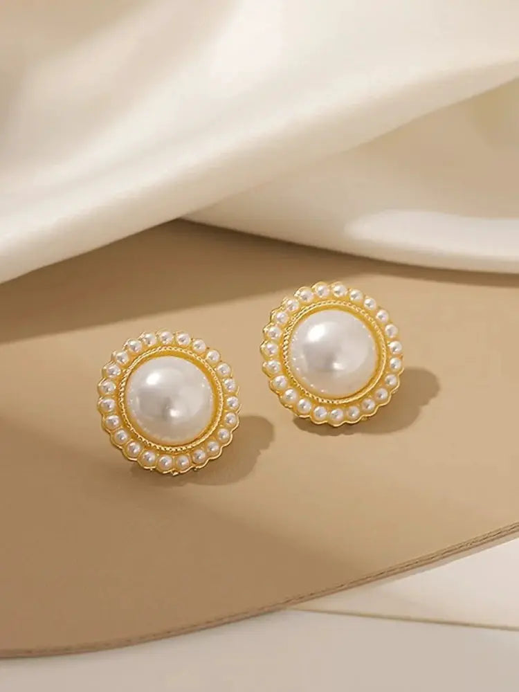 Pair of gold-tone pearl stud earrings with a large central white pearl surrounded by a border of small pearls