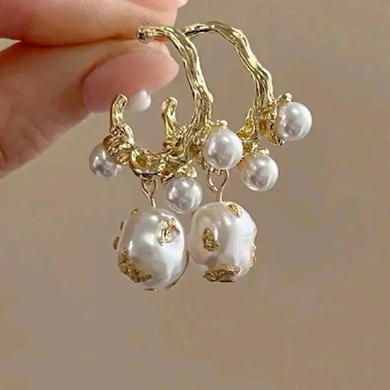 Gold-tone ocean-style pearl cluster earrings with shell-textured branches and dangling pearls