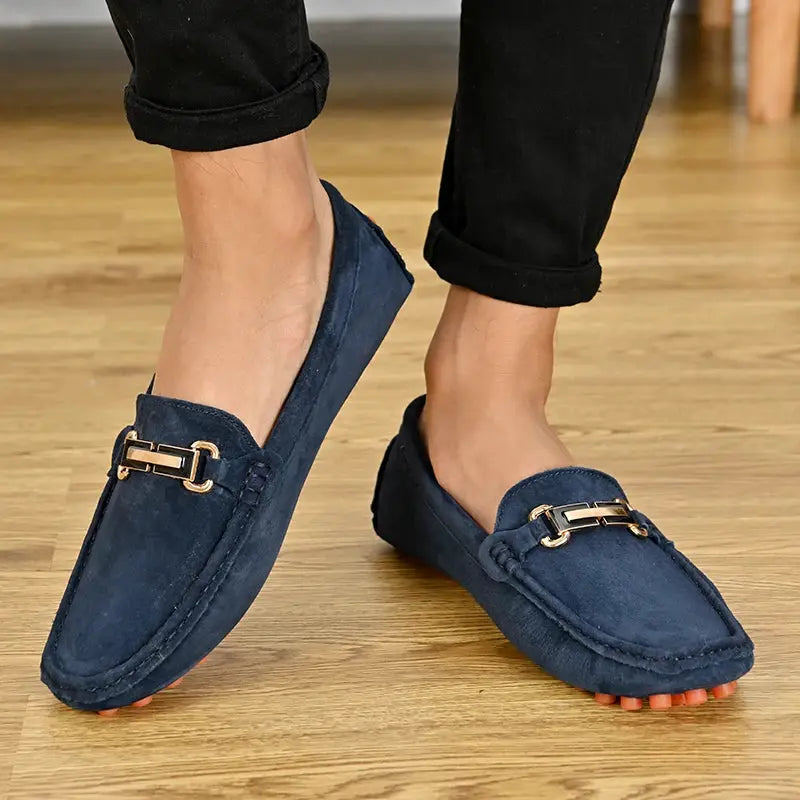 Men's navy blue suede loafers with gold horsebit, slip-on driving moccasins.